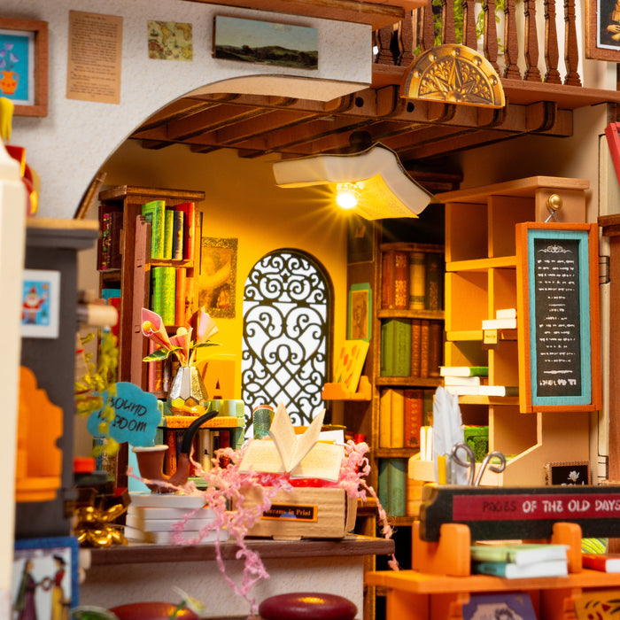 PageStory Books interior detail with arched door, hanging lamp, flowers and colorful shelves