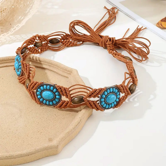 Ani Accessories Womens Belt Close-up of a brown macrame belt with central oval turquoise-colored stone medallions and small wooden beads interwoven into the cord.
