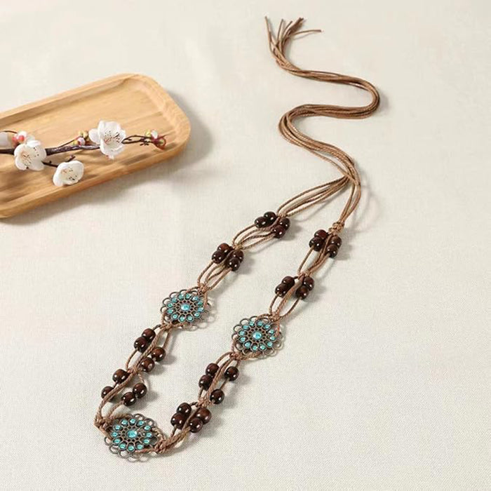 Women’s belt by Ani Accessories featuring bohemian wooden beads for waist styling on a creative background.