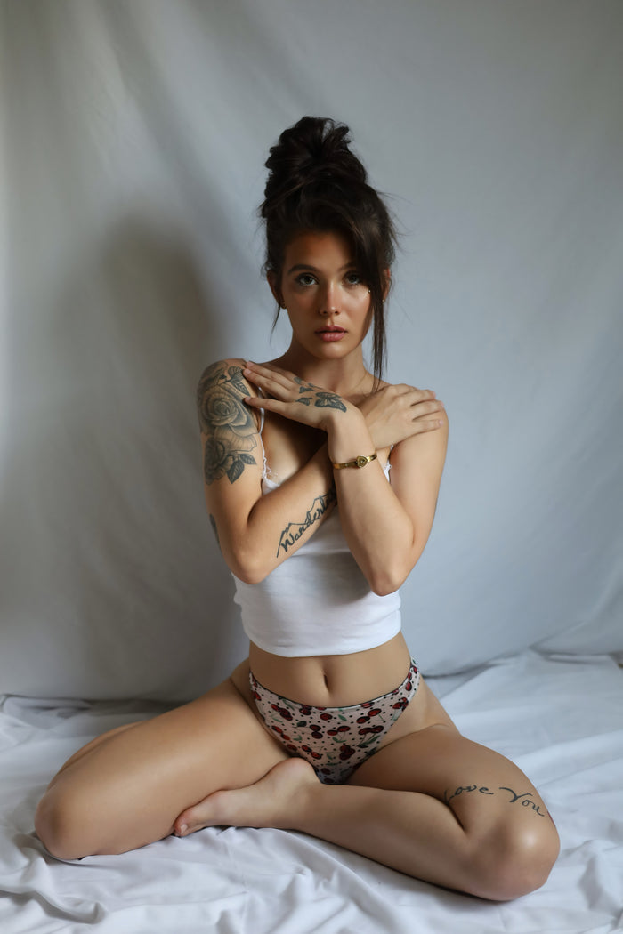 Cherry-print satin thong panties on model, front view with bikini coverage
