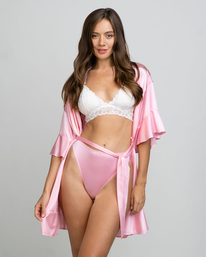 Pink satin short robe with tie waist over a white lace bralette and matching panties