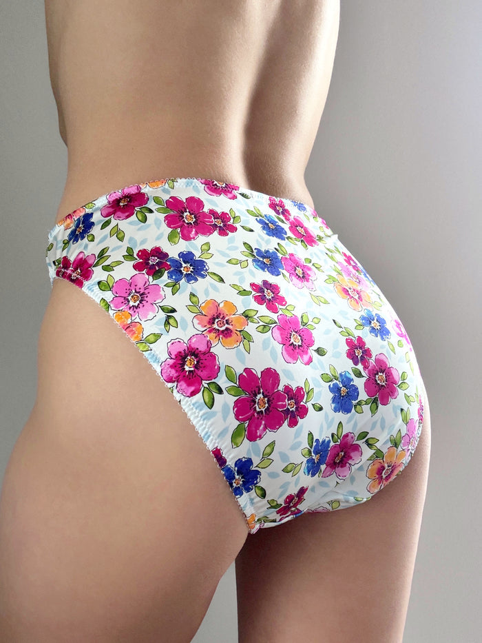 Floral bikini panty in white with multicolor blooms and gathered waistband.
