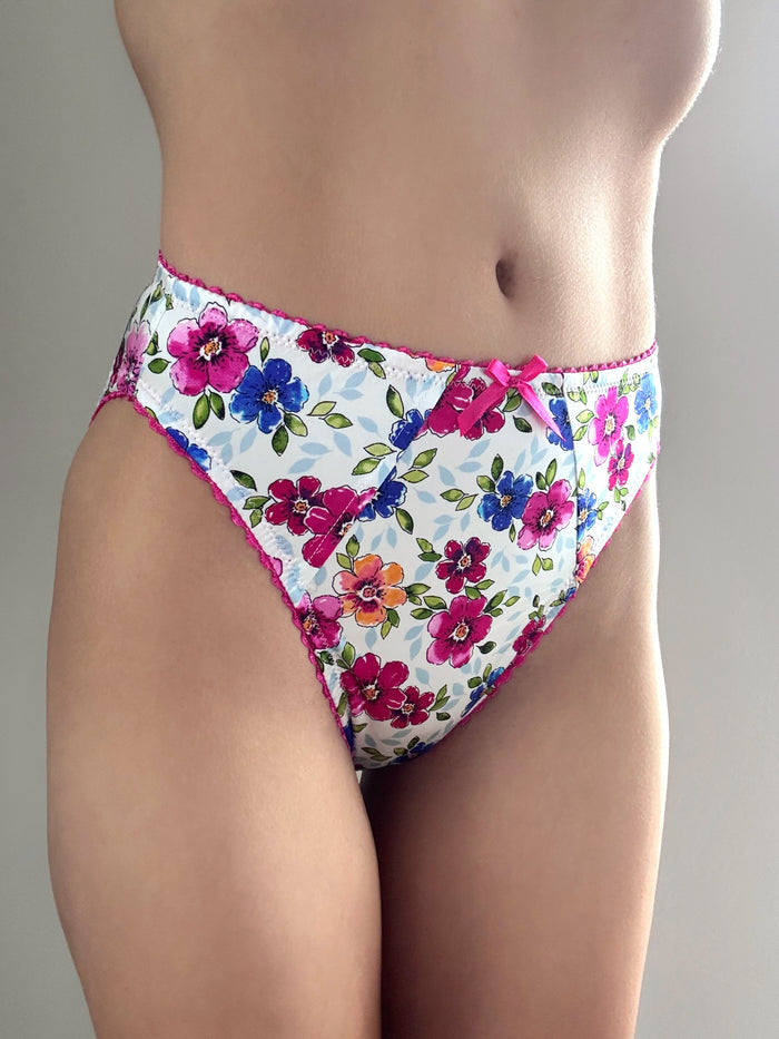 Floral panties with pink bow at waistband, white base with colorful flower print