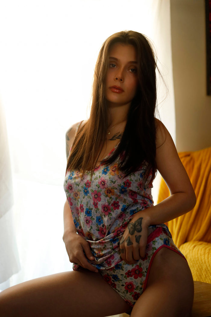 Floral bikini panties with pink waistband and multicolor flower print with dress visible