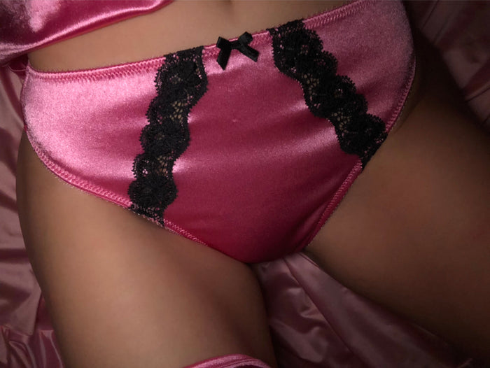 Bubblegum pink satin panty with black lace trim and bow detail at front