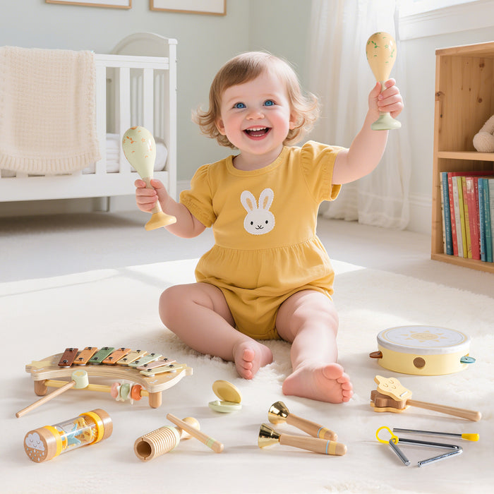 Smiling baby in yellow outfit playing with ROBUD Moonlight Music Set wooden instruments spread across a white nursery floor