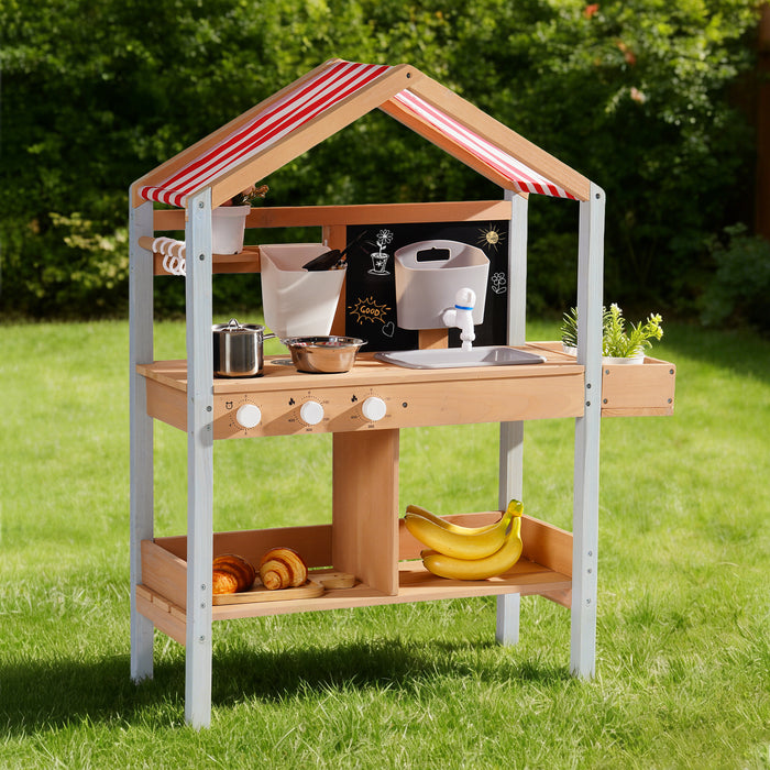 ROBUD outdoor mud kitchen with canopy standing alone on green lawn showing full structure with stainless knobs and two storage shelves