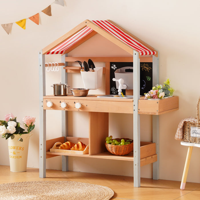 ROBUD outdoor mud kitchen placed outdoors among garden greenery showing chalkboard panel and accessory hooks without canopy