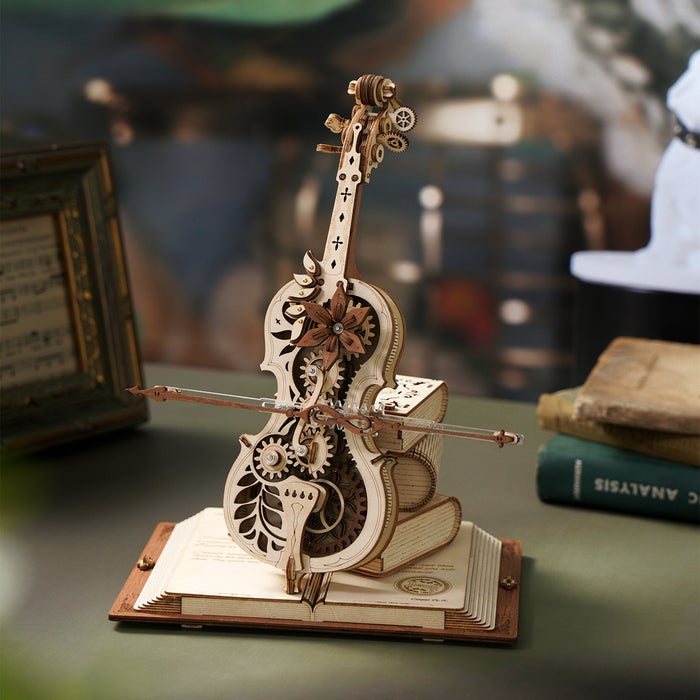 ROKR wooden cello music box with leaf and gear details on a book base among vintage books on a warm desk surface