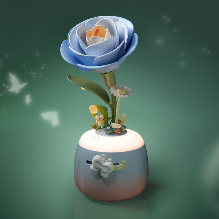 ROKR Starry Camellia Lamp AF01S, blue layered camellia blossom on glowing pink-blue gradient vase with miniature fairy garden scene at base