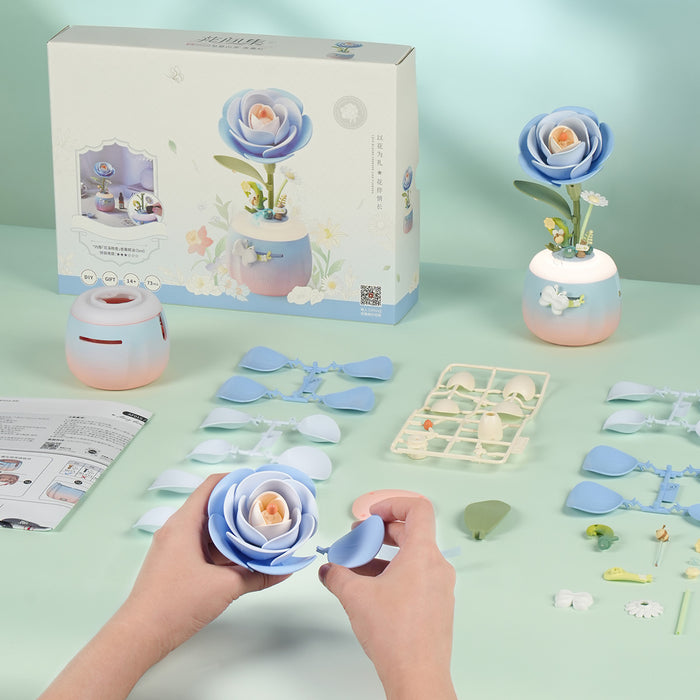 ROKR Starry Camellia Lamp AF01S blue rose assembly flat lay showing the blue petal parts, white sprues, rounded gradient vase base, and instruction sheet on a mint surface