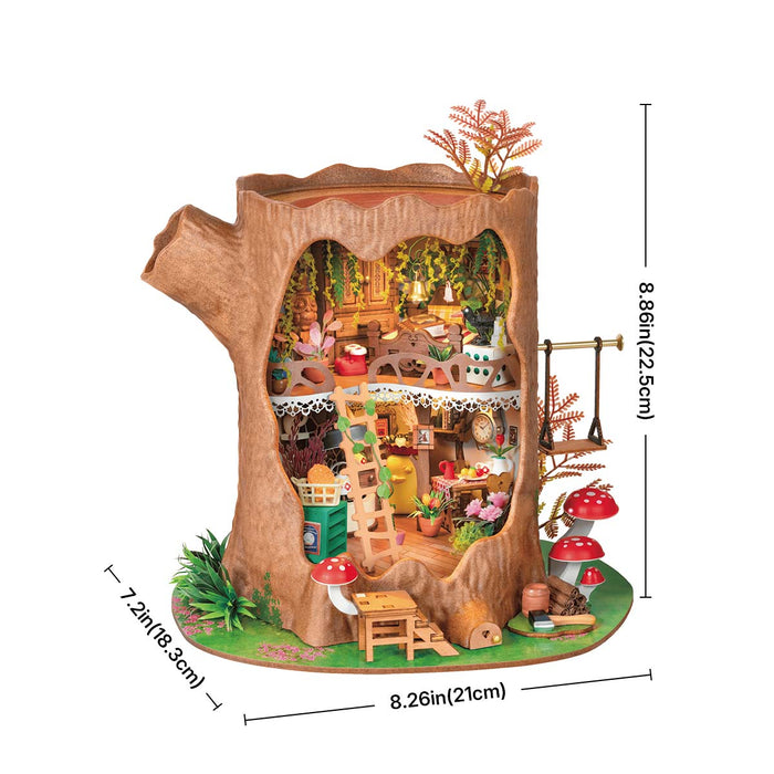 Rolife Fairytale Tree House DG179 placed in a magical forest scene with green moss, red mushrooms, white figurines, and golden hanging plants surrounding the lit tree trunk