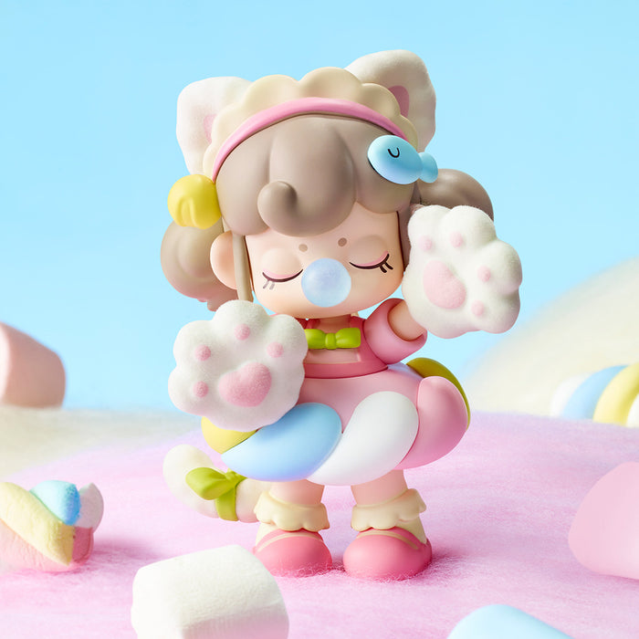 Close-up of a Rolife Nanci Sweet Time bear-paw costume doll with fluffy white paw mittens and a small fish clip in her hair against a pastel blue background
