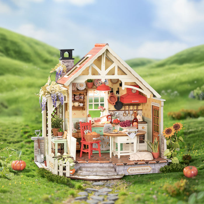 Rolife miniature farmhouse kit displayed on a grassy hillside with pumpkins and green rolling hills behind it