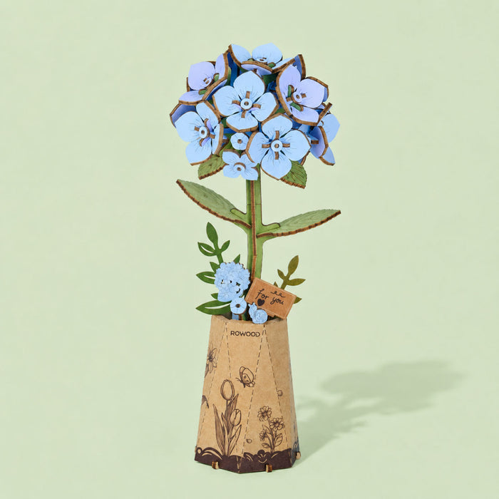 Blue wooden hydrangea in a tall cork patterned pot against a pale green background