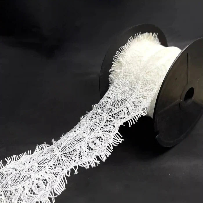 A roll of Scalloped Edge Eyelash Lace in white, perfect for crafting and decoration projects.