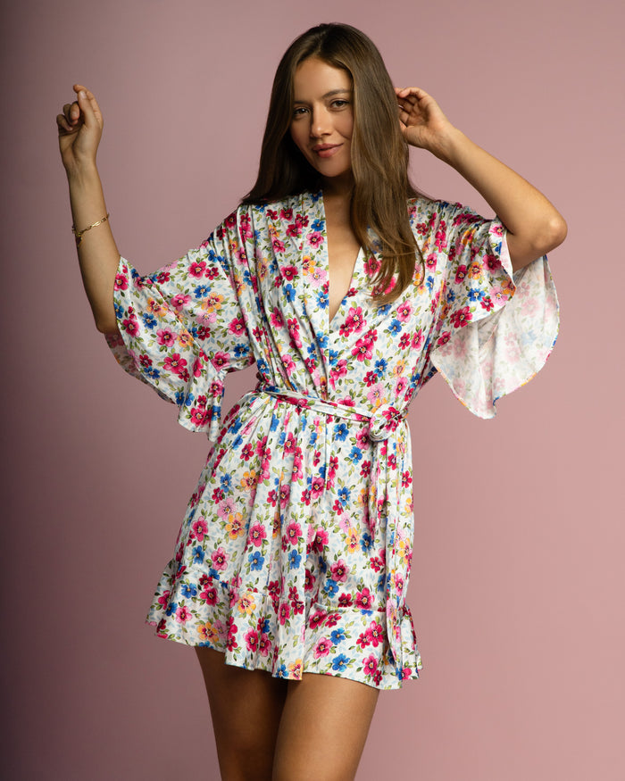 Short floral robe with tie waist, deep V-neck, and wide ruffled sleeves and hem.