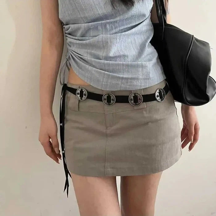 Ani Accessories women’s waist belt made from black suede with boho metal concho accents on a white background.
