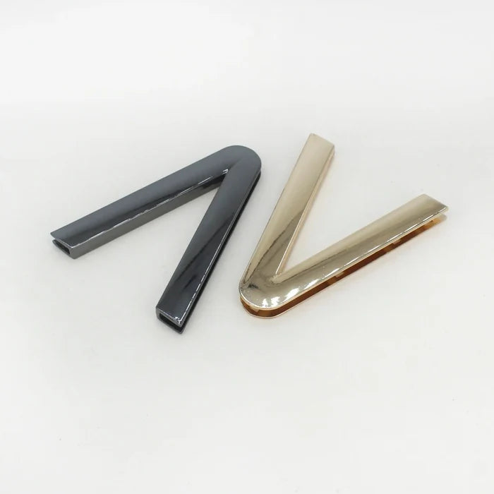 Ani Accessories V-Shaped Elegant Metal Black& gold Buckle placing in the white floor background.